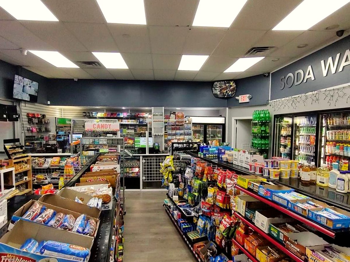 Inside the Snack & Go store with bright aisles of snacks, a candy section and soda coolers