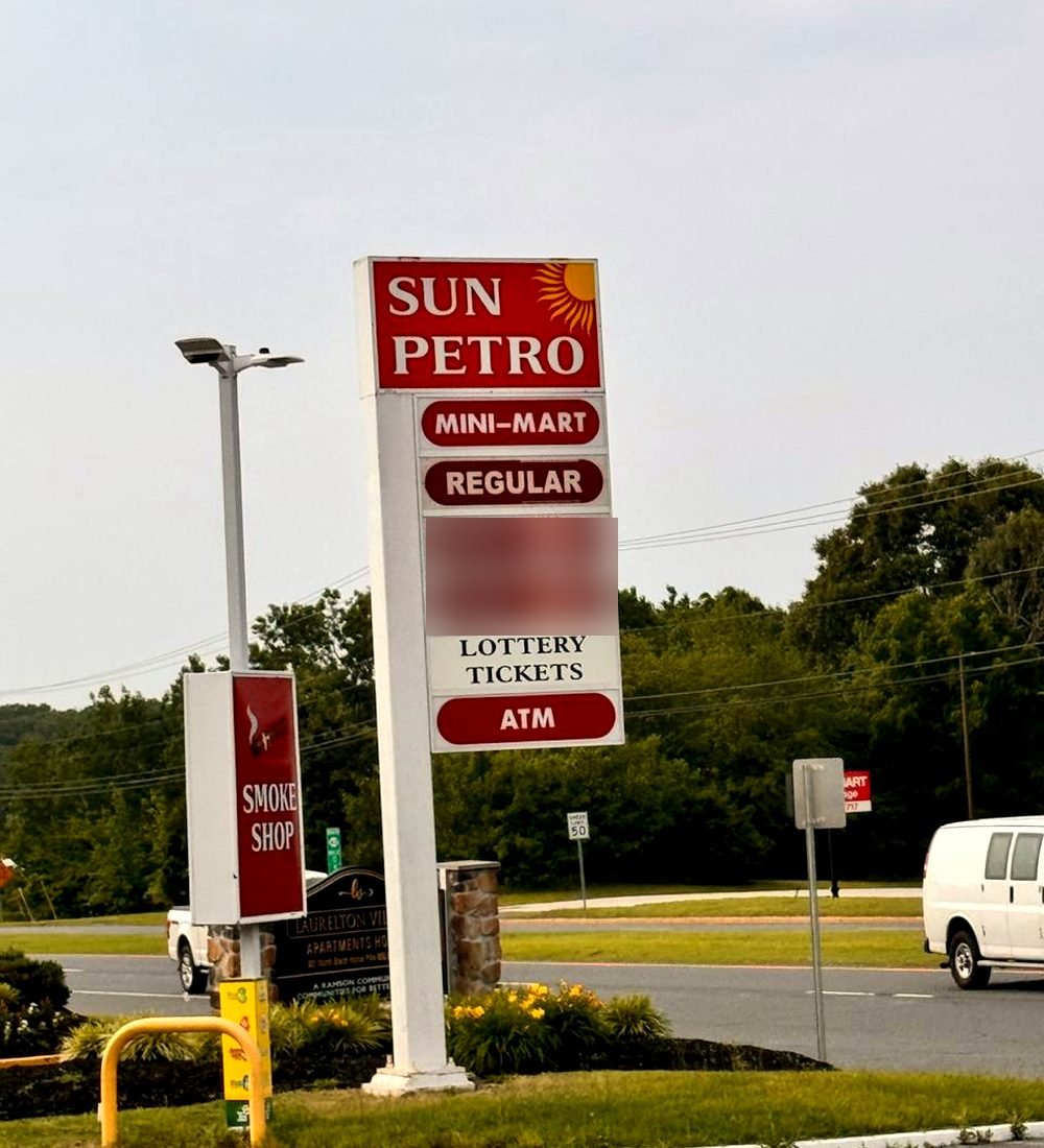 The Sun Petro roadside sign with its sun logo, advertising the mini-mart, lottery and ATM